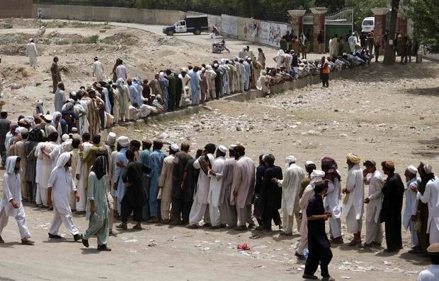 People who fled the military offensive against Pakistani militants in North Waziristan line up to receive food from the army in Bannu, in Pakistan's Khyber Pakhtunkhwa province