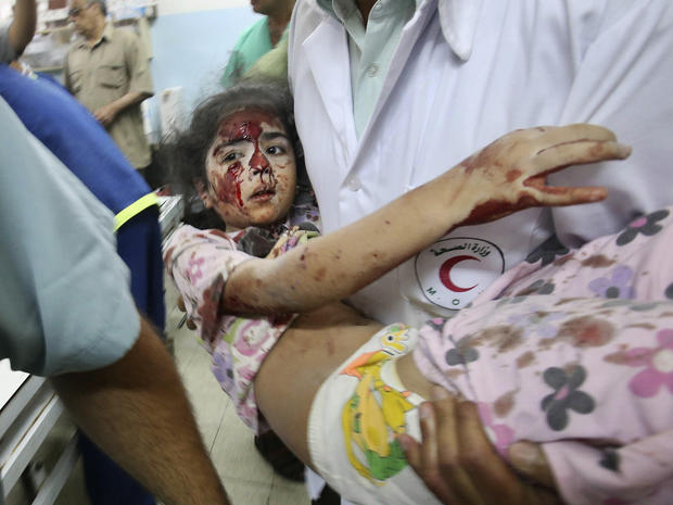 A Palestinian medic carries a girl who medics said was wounded by Israeli shelling, at a hospital in Khan Younis in the southern Gaza Strip 