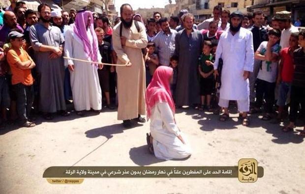 A member of ISIS' religious police flogs a man found guilty of violating Islamic law by breaking the fast for the Muslim holy month of Ramadan in the Syrian city of Raqqa 