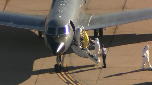 Ebola patient, Amber Vinson, seen in yellow suit, is boarding plane that will take her from Dallas to Emory University Hospital in Atlanta