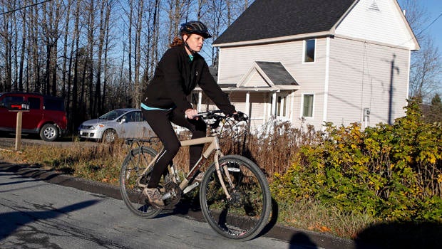 Nurse Kaci Hickox rides away from the home she is staying in on a rural road in Fort Kent, Maine, to take a bike ride Oct. 30, 2014.