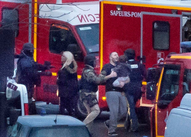 A security officer directs released hostages after police stormed a kosher market to end a hostage situation in Paris Jan. 9, 2015.