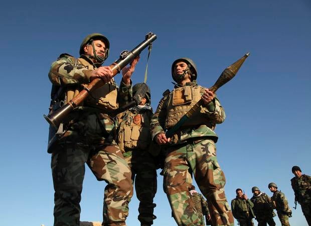 Kurdish Peshmerga fighters inspect an rocket-propelled grenade (RPG) launcher as they take control of the area, on the outskirts of Mosul Feb. 6, 2015.