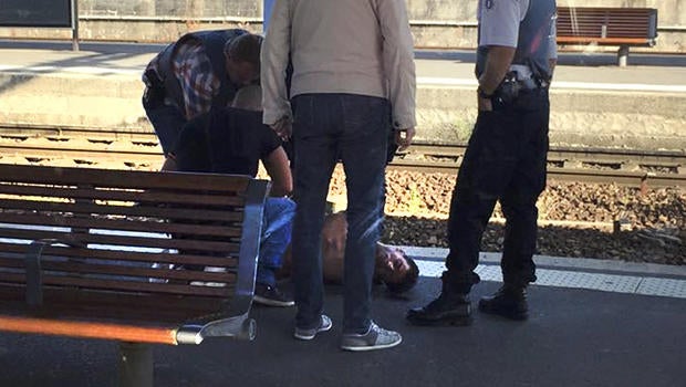 French police stand over a man who is apprehended on the platform at the Arras train station after shots were fired on the Amsterdam to Paris Thalys high-speed train in Arras, France, Aug. 21, 2015.