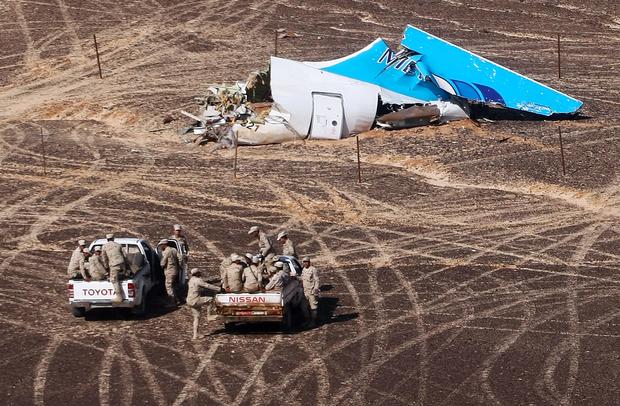 Egyptian Military personnel approach the tail of a Metrojet Airbus A321 which broke up in the air over Egypt's Sinai Peninsula
