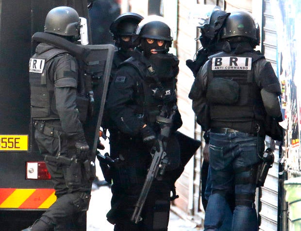French special police forces arrive at the scene as shots are exchanged in Saint-Denis, France, near Paris, Nov. 18, 2015, during an operation to catch suspects in the deadly attacks in the French capital.