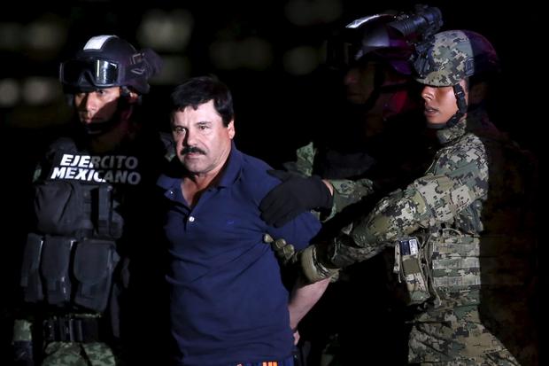 Joaquin "El Chapo" Guzman is escorted by soldiers during a presentation at the hangar belonging to the office of the attorney general in Mexico City, Mexico, Jan. 8, 2016.