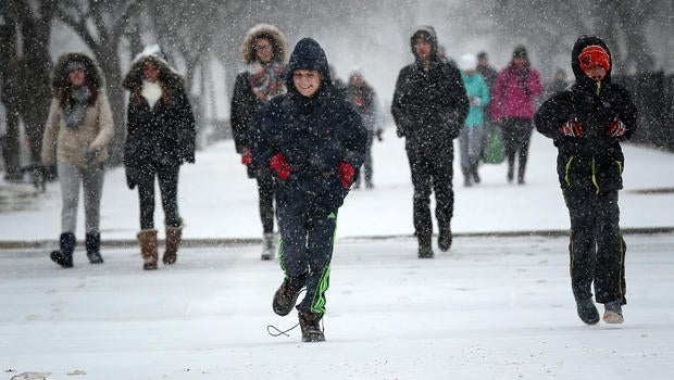 Schoolchildren run along the National Mall as snow begins to fall Jan. 22, 2016, in Washington, D.C.
