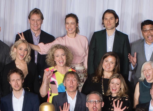 Brie Larson provides a fashion accessory to Jennifer Lawrence during the group photo session at the Oscar Nominees Luncheon at the Beverly Hilton in Beverly Hills, Calif., Feb. 8, 2016.