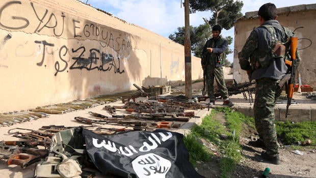 Fighters from the Democratic Forces of Syria inspect weapons and ammunition that, according to them, belonged to Islamic State of Iraq and Syria fighters in al-Shadadi, Syria, Feb. 26, 2016.