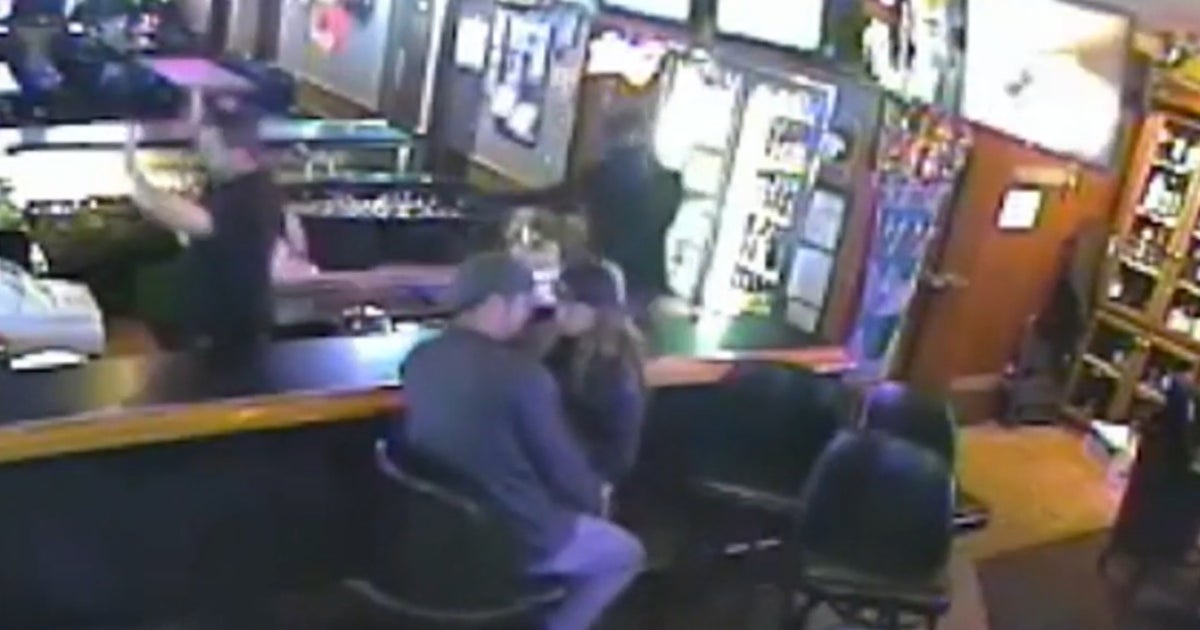 Seemingly oblivious couple kisses during bar robbery CBS News