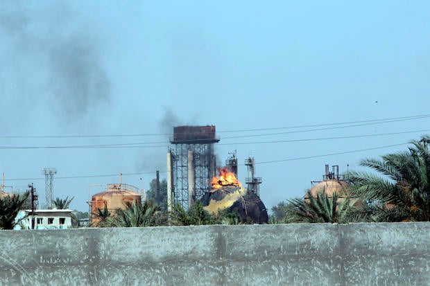 Flames and smoke rise from tanks after an ISIS suicide bomb attack on the Taji gas plant, about 12 miles north of the Iraqi capital Baghdad