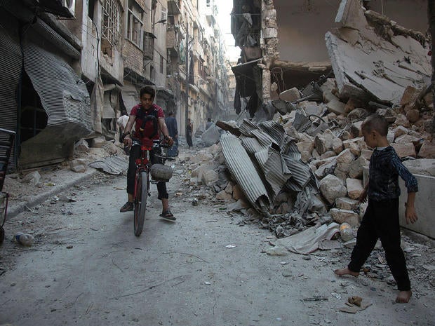Syrian boys play amid rubble following an airstrike on Aleppo’s rebel-controlled neighbourhood of Karm al-Jabal