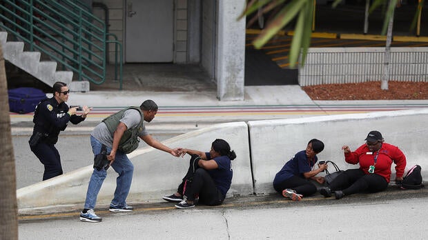 Police assist people seeking cover outside of Terminal 2 at Fort Lauderdale-Hollywood International Airport after a shooting took place in the baggage claim area on Jan. 6, 2017, in Fort Lauderdale, Florida.