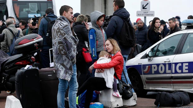 Travelers wait outside the Orly airport, south of Paris, March 18, 2017.