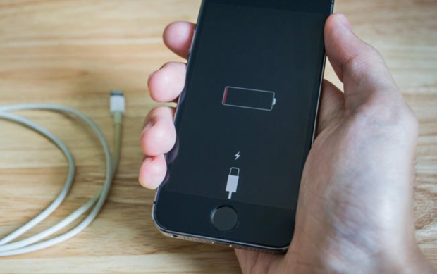 Bilde av hånd som holder iPhone med tomt batteri