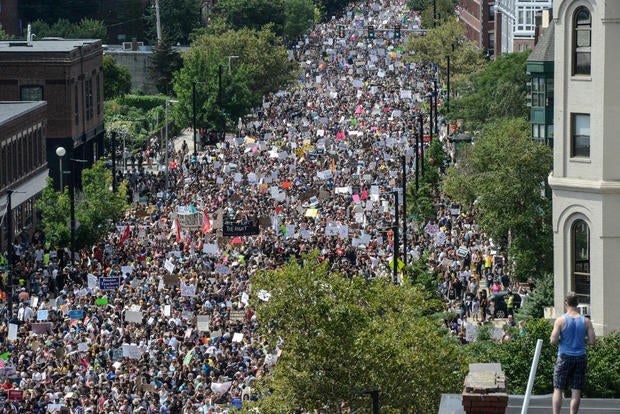 A large crowd of people march towards the Boston Commons to protest the Boston Free Speech Rally in Boston, MA
