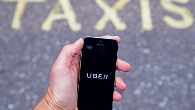 FILE PHOTO: A photo illustration shows the Uber app logo displayed on a mobile telephone, as it is held up for a posed photograph in central London 