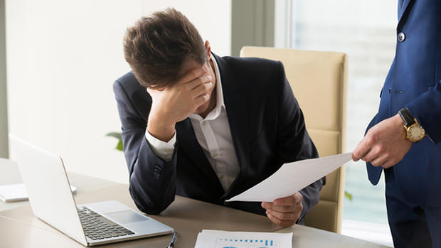 Sad manager getting notice of dismissal, document with bad news 