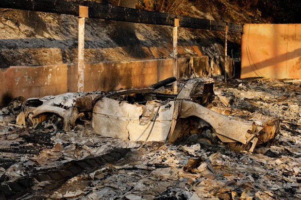 The burnt remains of an automobile is seen at the Hawaiian Village apartments after a wind-driven wildfire swept into the city of Ventura
