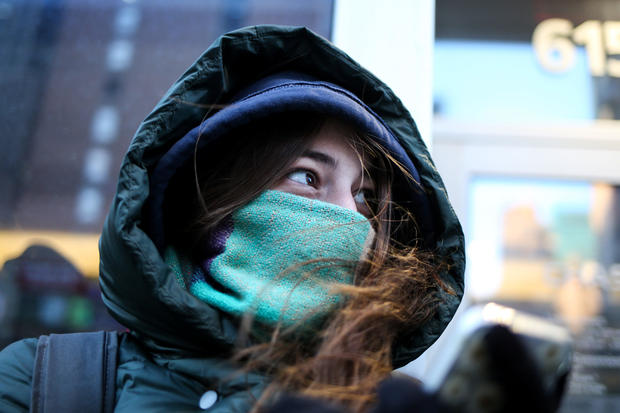 A woman bundles up against the cold temperature as she walks in New York 