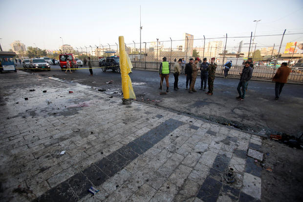 Iraqi security forces inspect the site of a bomb attack in Baghdad 