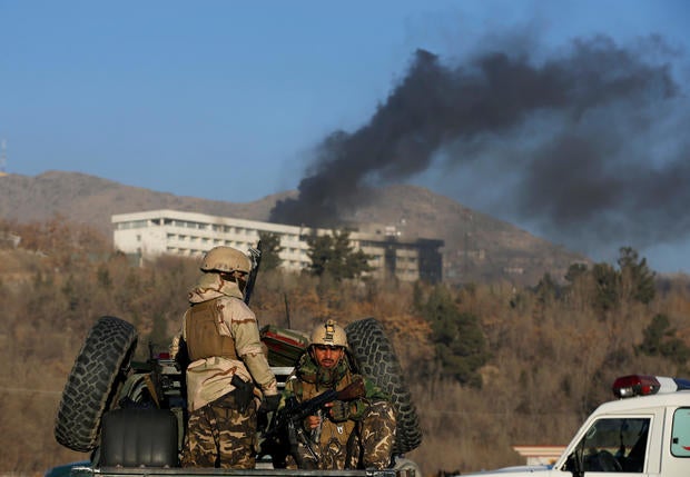 Afghan security forces keep watch as smoke rises from the Intercontinental Hotel in Kabul,ÊAfghanistan