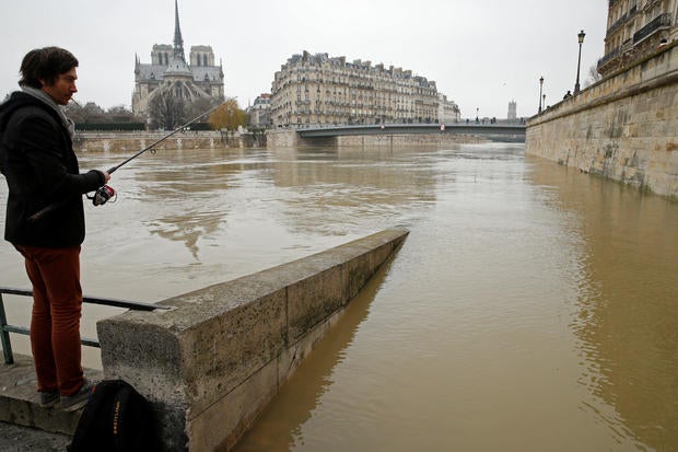 A man fishes on the flooded banks of the River Seine in Paris