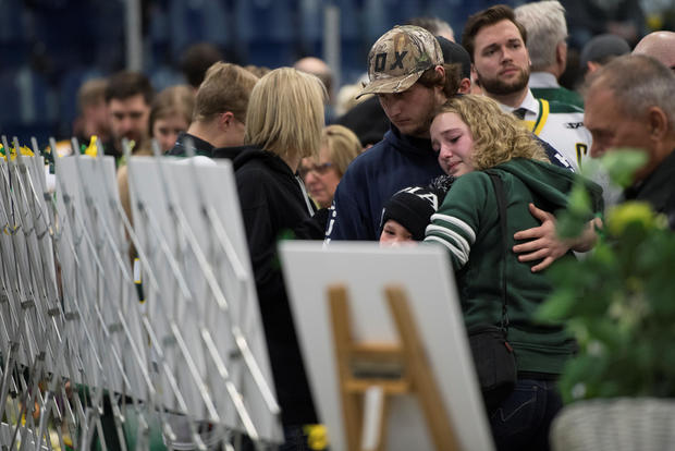 People look at photos of the victims during a vigil at the Elgar Petersen Arena, home of the Humboldt Broncos, to honour the victims of a fatal bus accident in Humboldt 