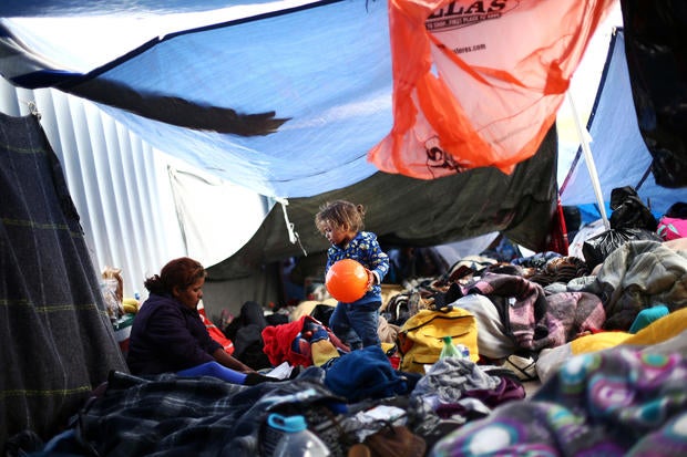 A child traveling with a caravan of migrants from Central America holds a ball at a camp near the San Ysidro checkpoint, after U.S. border authorities allowed the first small group of women and children entry from Mexico overnight, in Tijuana