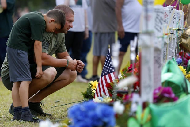 Mourners pray at a makeshift memorial left in memory of the victims killed in a shooting at Santa Fe High School in Santa Fe