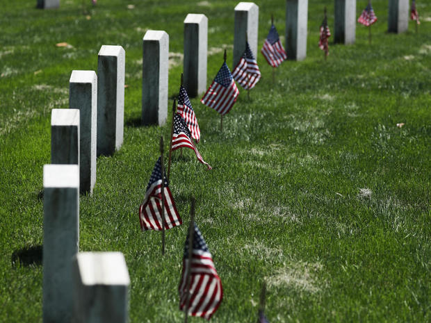 U.S. flags placed by U.S. Army soldiers of the 3rd United States Infantry Regiment lie on graves at Arlington National Cemetery 