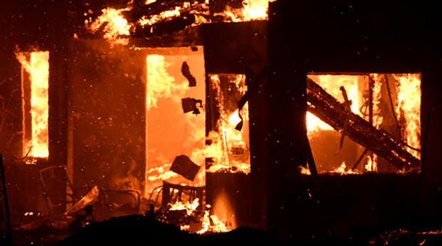A house burns as firefighters battle flames at a home at the site of a wildfire in Goleta 