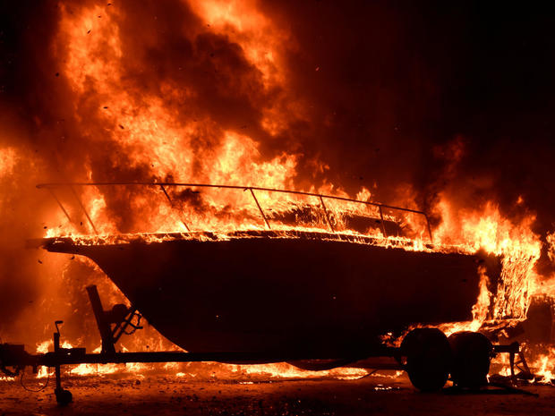 A boat burns as fast-moving wildfire driven by strong wind and high temperatures at the site of a wildfire in Goleta 