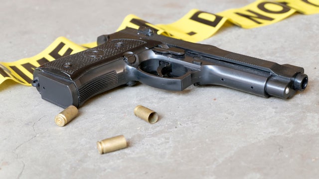 Crime scene concept with gun and three casings - handgun, police tape, generic 