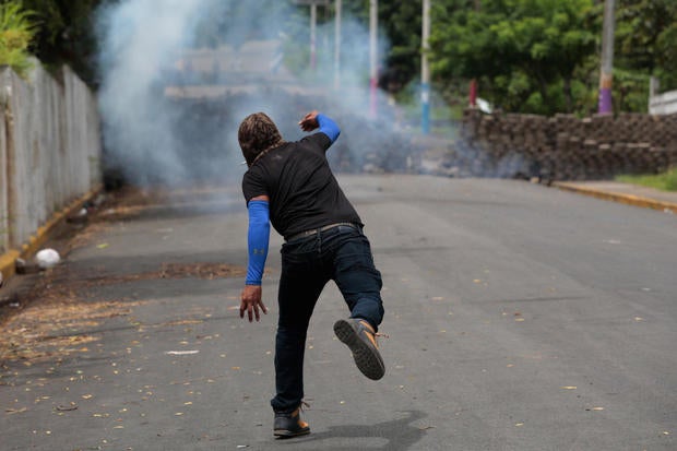 Demonstrator throws a homemade device during the funeral service of Jose Esteban Sevilla Medina, who died during clashes with pro-government supporters in Monimbo