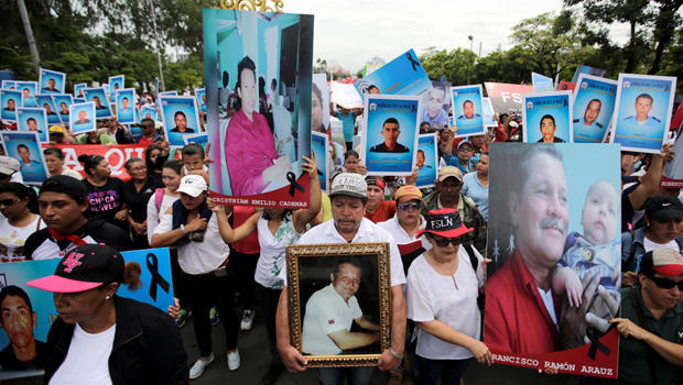 Ortega supporters hold pictures of dead police officers at demonstration in Managua 