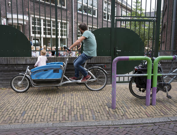 father waits with cargo bike in dutch town of delft 