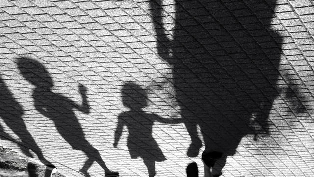 Blurry shadow of a little boy and a girl walking with adults 