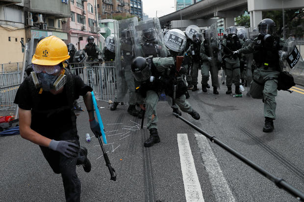 Riot police chase a demonstrator during a protest against the Yuen Long attacks in Yuen Long 
