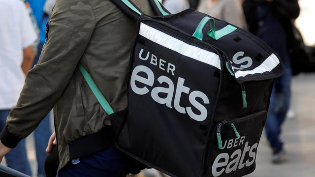 A biker, wearing a 'Uber Eats' food courier backpack, demonstrates during a call on clients to boycott Deliveroo in Paris 