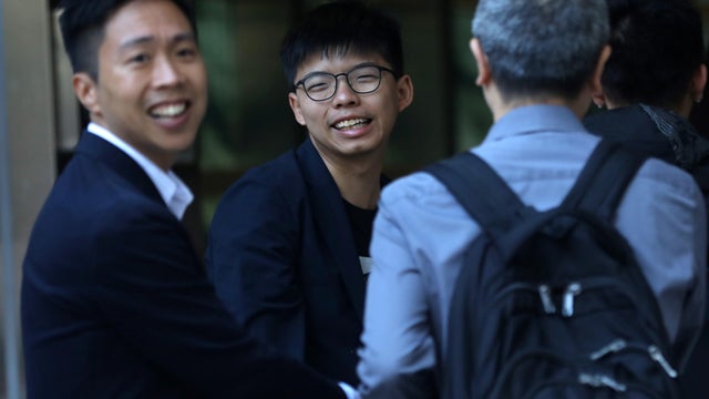 Winning candidate Kelvin Lam and activist Joshua Wong greet people and thank them for their support, outside South Horizons Station, in Hong Kong 