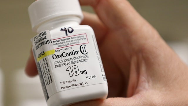 A pharmacist holds a bottle OxyContin made by Purdue Pharma at a pharmacy in Provo, Utah