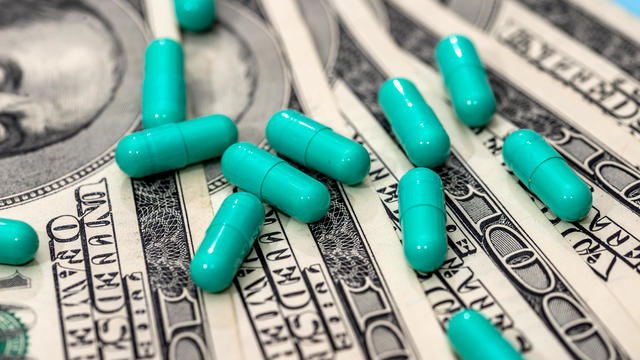 Medicines capsules on dollar bills close up 