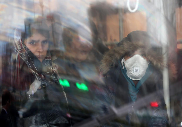 An Iranian woman wears a protective masks to prevent contracting coronavirus, as she sits in the bus in Tehran 