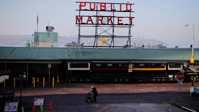 A woman walks through empty streets outside the Public Market, amid the coronavirus disease outbreak, in Seattle