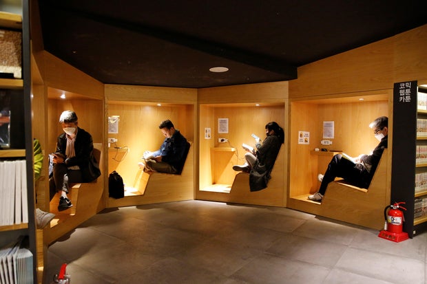 Health People wearing face masks to protect against contracting the coronavirus disease (COVID-19), sit a bookstore in central Seoul
