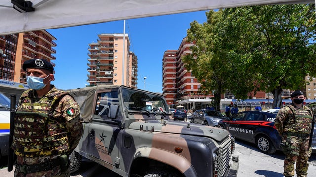 Italian police and Army personnel surround the red zone, 