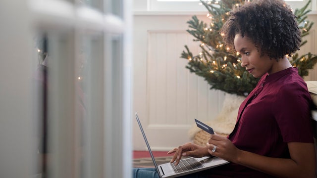Woman online shopping on laptop at Christmas