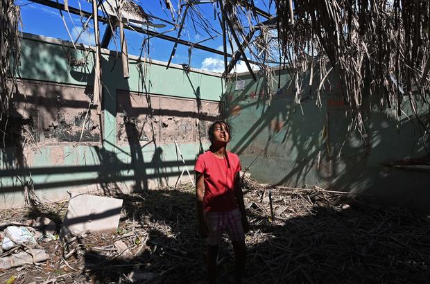 Girl stands in roofless house destroyed by hurricanes in Honduras 